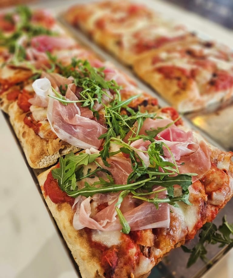 Pinsa topped with Parma ham and rocket