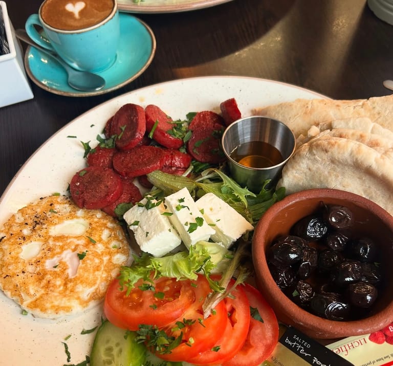 A Turkish breakfast plate with sucuk, feta and olives