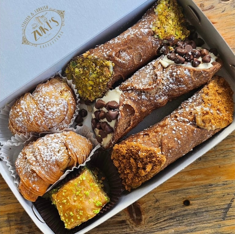A tray of assorted cannoli and pastries
